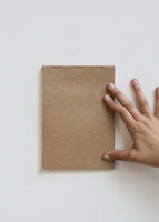 brown kraft card held up by a hand